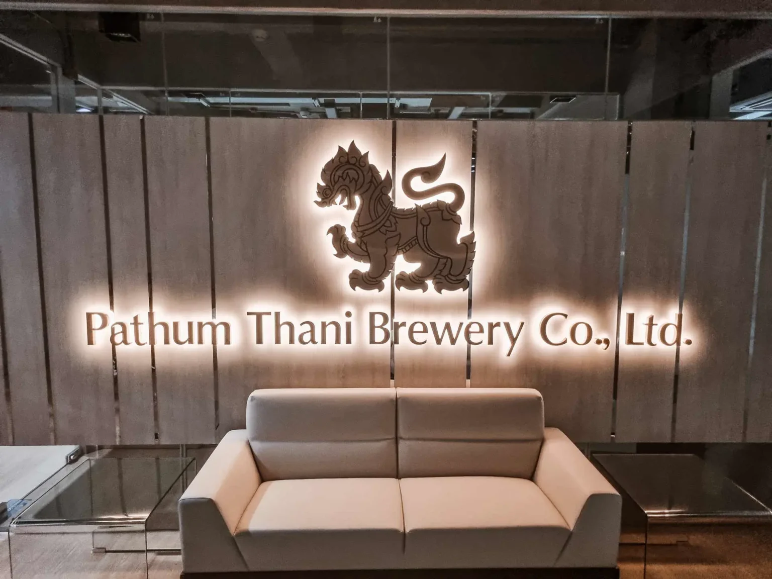 Logo der Pathum Thani Brewery im Eingangsbereich des Sitzes in Thailand