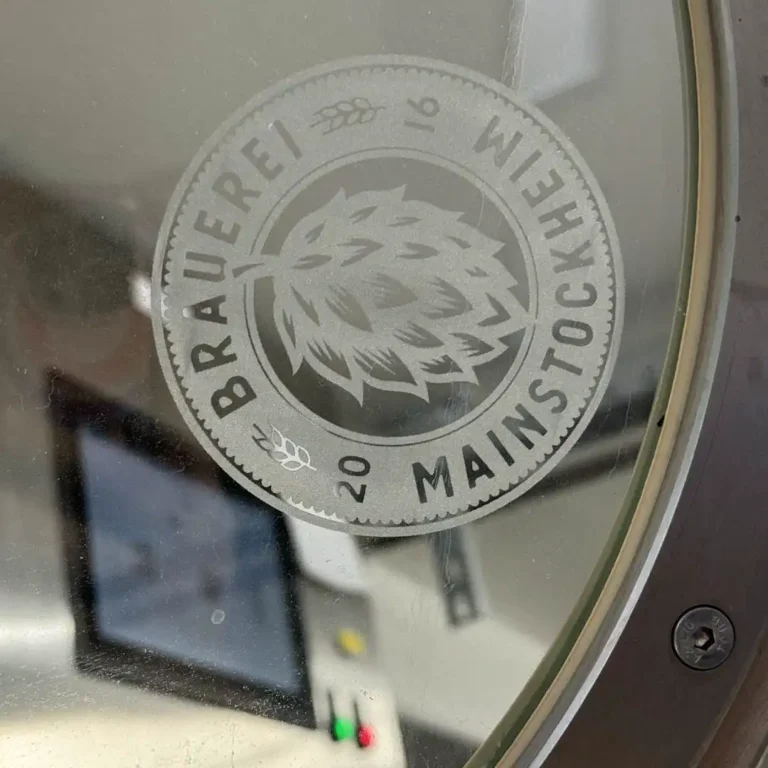 Das Logo der Brauerei Mainstockheim auf dem Deckel des Braukessels